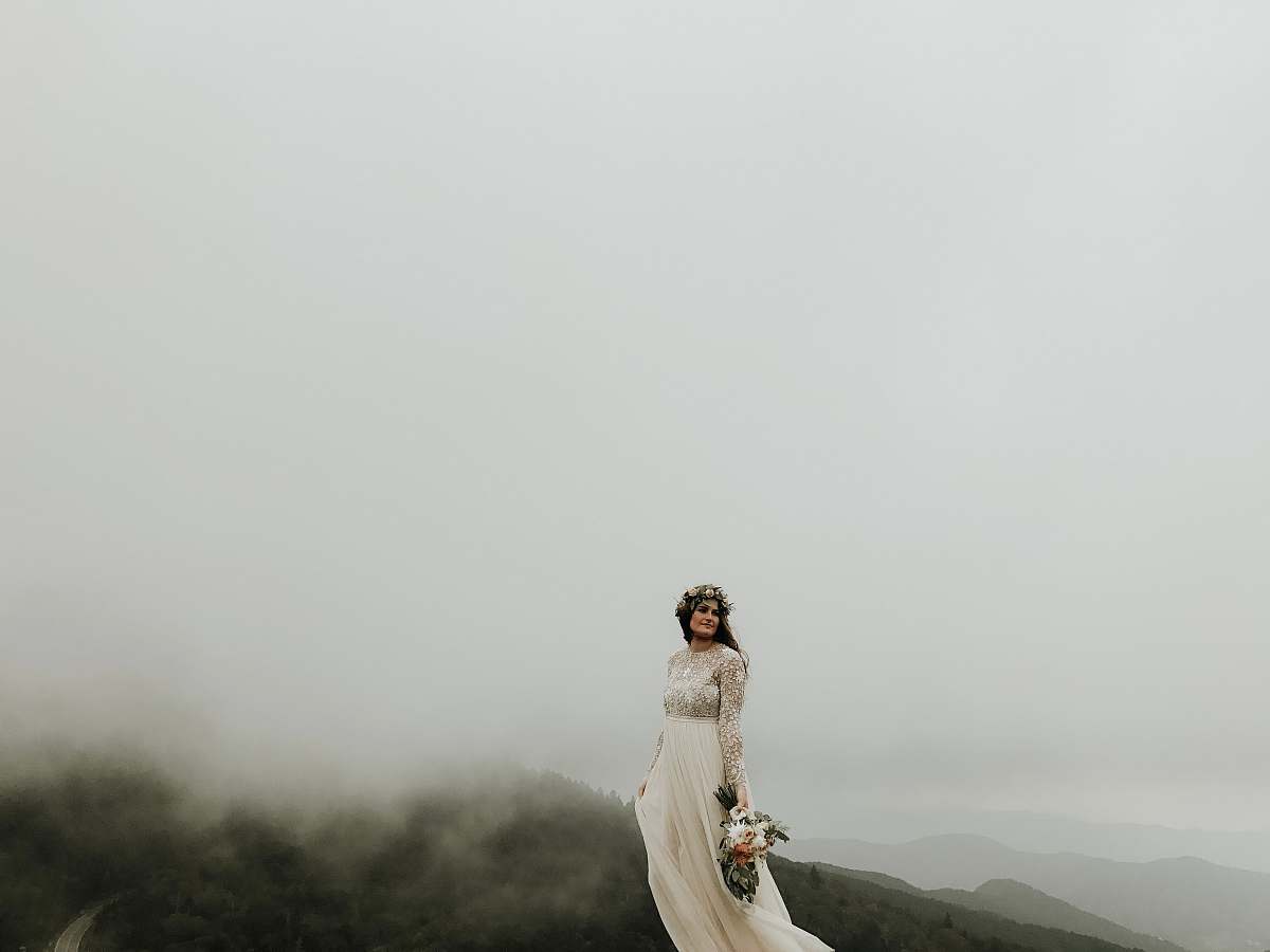 carver's gap woman wearing wedding gown standing on top of hill bakersville